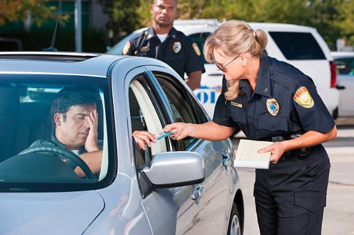 Police officer inspecting vehicle during traffic stop